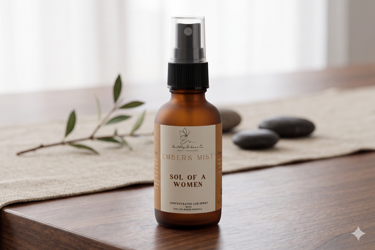 A 1oz frosted amber bottle of Earthly Embers Co. Embers Mist concentrated car spray in the scent Sol of a Women, featuring a black spray nozzle and clear cap on a wooden table.